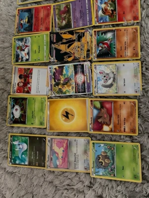 Samling Pokémonkort blandade typer - Säljer en samling Pokémonkort med olika typer och energikort. Blandningen innehåller både vanliga och holografiska kort med färgglada illustrationer. Perfekt för dig som vill utöka din samling eller börja spela Pokémon TCG.