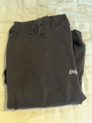 Svart hoodie från Jack & Jones - Säljer en svart hoodie från Jack & Jones Originals med liten vit textdetalj på bröstet. Klassisk modell med huva och dragsko. Mjuk insida och ribbade muddar. Perfekt för en avslappnad och stilren look. Kontakta för intresse/frågor!