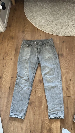 Grå raka jeans med fem fickor - Snygga grå jeans med rak passform och klassisk femficksdesign. Jeansen har normal midja och stängs med knapp och dragkedja. Perfekta för en avslappnad och trendig look. Materialet är denim i bomull.