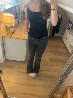 Mörkgrå bootcut jeans - Säljer ett par mörkgrå bootcut jeans med low-mid rise. De är lite slitna längst ner men är annars i bra skick!
