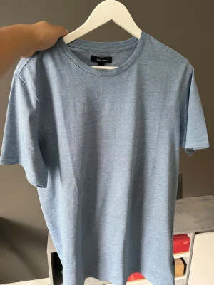 Ljusblå t-shirt från Matinique - Snygg ljusblå t-shirt från Matinique i storlek L. Tillverkad i mjukt och tunt material med klassisk rund halsringning och korta ärmar. Perfekt basplagg för en clean och stilren look.