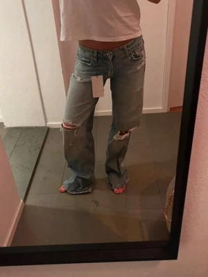 Ljusblå slitna raka jeans - Helt nya jeans från Zara som är low waist straight/baggy💕 Skriv innan köp!