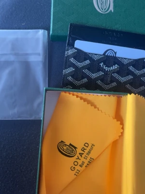 Svart plånbok  - Passar bra i fikan och fin färg med de flesta byxor, bra och skön material och hålla i den i. Bra och lägga kort och cash i.
