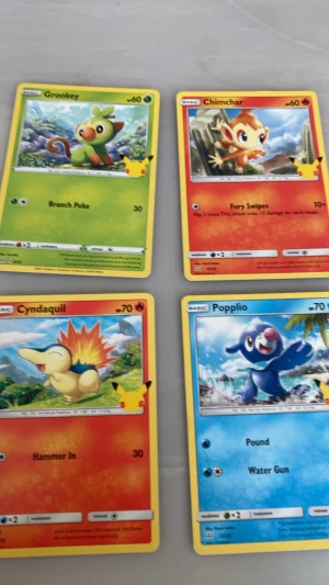 Fyra Pokémon samlarkort - Säljer fyra Pokémon samlarkort: Grookey (grön), Chimchar (orange/röd), Cyndaquil (gul/röd) och Popplio (blå). Korten har färgstarka illustrationer och klassisk Pokémon-design. Perfekt för dig som gillar att samla eller spela Pokémonkort.