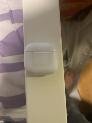 Vita trådlösa in-ear hörlurar - Säljer ett par vita trådlösa in-ear hörlurar med laddningsetui. Hörlurarna har en stilren och kompakt design med mjuka silikonproppar och laddningsindikator på framsidan av etuiet. Perfekta för musik, poddar och samtal på språng.