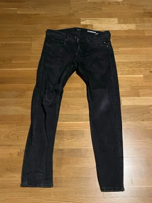 Svarta straight fit jeans Replay - Säljer ett par svarta jeans från Replay, modell Grover Straight Fit. Klassisk femficksdesign med raka ben och knappgylf. Jeansen är i ett mjukt denimtyg och har diskreta detaljer vid fickorna. Perfekta för en clean och stilren look.