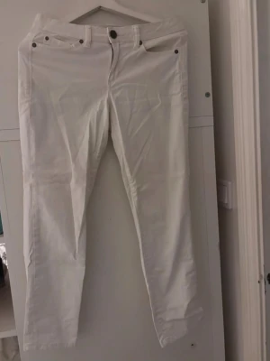 Vita jeans från Calvin Klein Jeans - Säljer ett par stilrena vita jeans från Calvin Klein Jeans. De har klassisk femficksmodell, raka ben och normal midja. Perfekta för dig som vill ha en clean och fräsch look. Materialet känns mjukt och bekvämt, och de passar till många olika stilar.