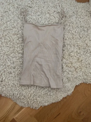 Beige ribbad ärmlös topp - Aldrig använt!  Jag står inte för frakt, tar gärna emot bud under det satta priset för kompromiss!💗   Allt jag säljer är i stort sätt i nytt skick för ett lägre pris, kolla in resten av mina artiklar i min profil!
