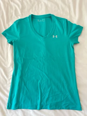 Sport t-shirt Under Armour - Snygg turkos t-shirt från Under Armour med v-ringning och korta ärmar. Perfekt för träning eller chill dagar!