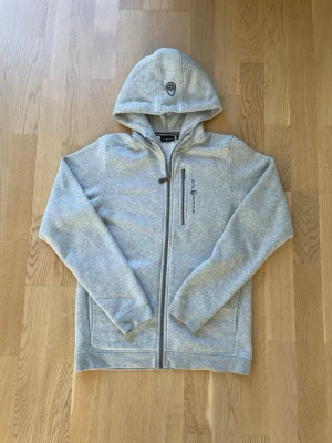 Sail Racing Zip Hoodie Grå - Säljer denna tvärfeta zip hoodien från Sail Raicing. Jävligt bra skick på denna. Perfekt nu inför höst/vinter säsongen.