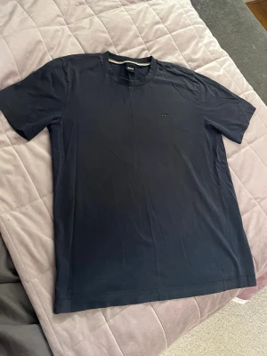 Svart BOSS t-shirt i bomull  - Den är i super skick men den har några små hål längst ner på tröjan, ganska svårt att se men syns vid väldigt nära håll. Skriv gärna för frågor!