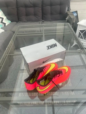 Nike Hypervenom FG Pink/Volt – Strl 43 – Originalkartong - Nike Hypervenom FG i den ikoniska rosa/gula färgställningen. Storlek 43 (US 9.5). Skorna är i mycket fint skick med fräscha dobbar och levereras med originalkartong. Passar perfekt för naturgräs och är en modell som blivit allt mer eftertraktad.  📦 Originalkartong ingår 📏 Storlek 43 ⚽ FG (Firm Ground) ✅ Mycket fint skick 🚚 Skickas snabbt eller möts upp vid överenskommelse