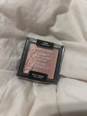 Wet n Wild Megaglo Highlighter - Wet n Wild Megaglo Highlighting Powder i nyansen Precious Petals. En pressad highlighter i puderform med en skimrande, ljusrosa ton och ett vackert mönster i pudret. Perfekt för att ge glow till ansiktet. Kommer i en fyrkantig plastförpackning. Har använt den en gång.