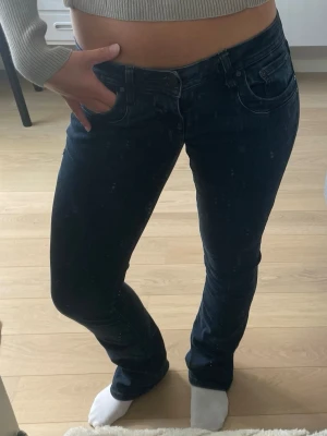 Mörkblå bootcut jeans - Säljer ett par mörkblå bootcut jeans med klassisk femficksdesign och låg midja. Jeansen har en smal passform upptill och lätt utsvängda ben. Perfekta till sneakers eller boots och passar dig som gillar en tidlös look. Går inte att köpa längre och är i jättefint skick!🥰Skriv för fler bilder eller om ni har frågor! Dem är mörkblå men väldigt mycket åt de svarta hållet. Jag är 167 cm