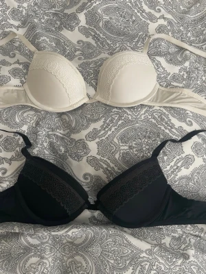 2-pack bhar från Calvin Klein spets - Säljer två snygga bhar från Calvin Klein i storlek 70A. En är vit och en är svart, båda med vadderade kupor och dekorativ spets upptill. Köp 1 för 165kr eller 2 för 290kr 