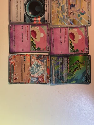 6 Pokémonkort med olika motiv - Säljer ett set med 6 Pokémonkort i färgglada designer. Bland motiven finns Slowpoke, Primate, Energy, samt två holografiska kort med coola illustrationer. Korten är tillverkade i laminerad papp och har klassisk Pokémon-baksida. Priset kan diskuteras 