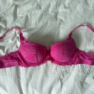 Rosa spets-bh med vaddering - Snygg, hot pink bh ifrån Victoria secret PINK. BHn har snygg lace-detalj och är väldigt bekväm. Lite oklart vilken storlek bhn är, då jag har klippt av lappen, men är säker på att det är en B-kupa.  Bh storleken är förmodligen 34B, eller 32B, lutar nog mest mot 34B - vilket motsvarar 75B i svenska storlekar!!  Skriv om du har andra frågor om mått, eller något annat💕☺️🙌🏼