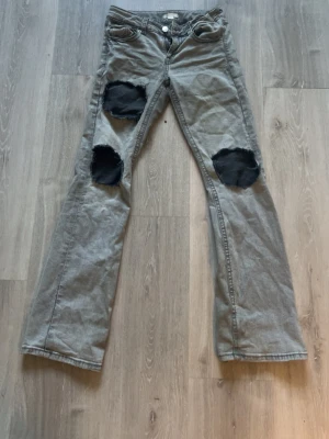 Grå egen klippta lågmidjade bootcut jeans  - Grå egen klippta jeans från Gina. Lågmidjade och bootcut. 