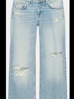 Ljusblå slitna raka jeans - Säljer ett par ljusblå jeans med raka ben och flera slitningar och hål framtill. Jeansen har klassisk femficksmodell och är tillverkade i denim med en avslappnad vibe. Perfekta för en trendig och avslappnad look. Använda 1 gång!!!