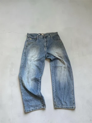 Southpole Jeans  - Southpole Baggy Jeans. Mått: Midja: 47cm Längd: 107cm Benöppning: 25cm.             Har ett litet hål på högra bakfickan, men är enkelt att fixa. kom dm för andra funderingar, respektive fler bilder. 