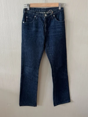 Mörkblå raka jeans från Armani Jeans  - Snygga mörkblå jeans från Armani med rak passform och klassisk femficksdesign. Jeansen har en diskret logga på bakfickan och är tillverkade i denim med en stilren look. Perfekta för dig som gillar en tidlös och enkel stil. 0089