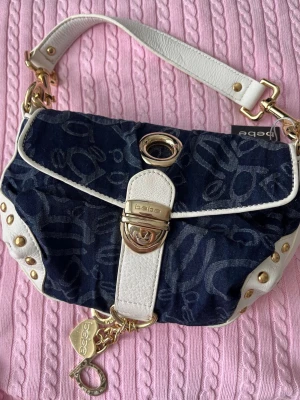 Bebe Y2K väska med monogram och gulddetaljer - Så unik och fin väska från Bebe. Kommer inte till användning längre! :) Vita detaljerna av läder