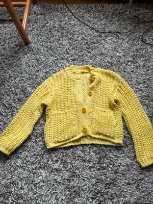 Chunky gul stickad kofta med smiley knappar - Säljer denna chunky gula koftan med smiley knappar. Tröjan är köpt i Courchevel där den är handgjord. Nypris 1200 kr. Sitter som en M. Eller oversized S. 