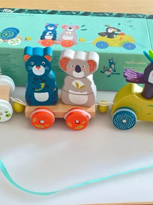 Färgglatt träleksakståg med djur - Säljer ett färgglatt träleksakståg med stapelbara djurfigurer som leopard, koala och fågel. Tåget har hjul i orange, blått och vitt samt detaljerade målningar. Perfekt för lek och utveckling av motorik. Tillverkad i trä med fina färger och mönster.
