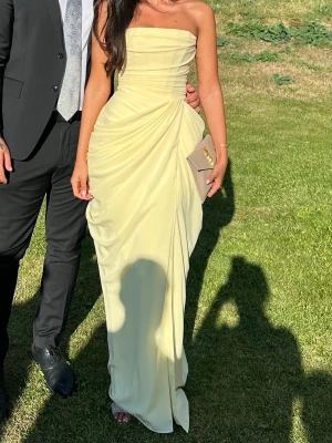 Babyboo gul maxi klänning - Klänning från babyboo fashion i storlek S. Korsett med snörning i bak så går att justera. Jag har sytt ihop slitsen 15cm, men går att sprätta upp 💛