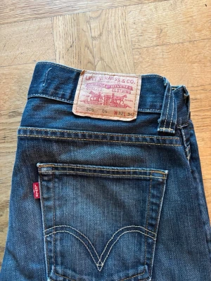 Levi's 506 raka blå jeans - Klassiska Levi's 505 jeans i mörkblå denim med raka ben och femficksmodell. Snygga kontrastsömmar och ikonisk röd Levi's-tag på bakfickan. Tillverkade i slitstarkt bomullsmaterial och passar perfekt till en avslappnad stil. Svår modell att få tag på. Om ni önskar mått vänligen kom dm så löser jag detta😁
