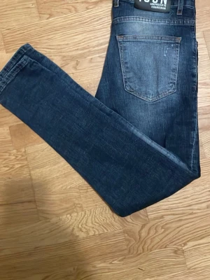 dsq jeans - Snygga mörkblå skinny jeans med slitningar och lätt tvättade detaljer på framsidan. Jeansen har klassisk femficksdesign och smal passform. Perfekta för en trendig och avslappnad stil.