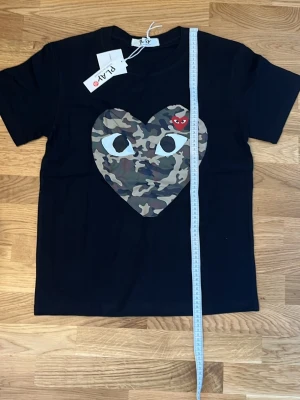 Svart t-shirt med camo-hjärta - Svart comme des garcons cammoflaugehjärta