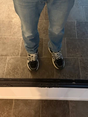 Svarta och vita sneakers med vita snören - Snygga sneakers i svart och vitt med vita snören och tydliga kontrastdetaljer. Skorna har en klassisk låg siluett och passar perfekt till jeans eller andra casual outfits. Materialet ser ut att vara en mix av textil och syntet perfekt till dig som vill ha ett par sköna dojor inför vintern.