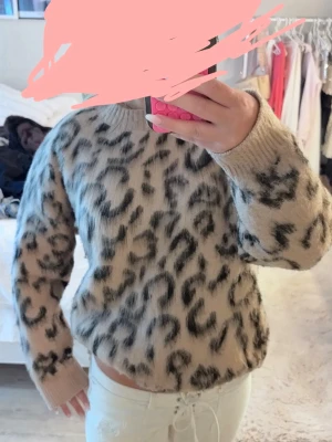 Beige leopardmönstrad stickad tröja - Säljer en beige stickad tröja i storlek S med svart leopardmönster. Tröjan har rund halsringning, långa ärmar och är gjord i ett mjukt, fluffigt material som känns riktigt cozy. Perfekt nu inför hösten!