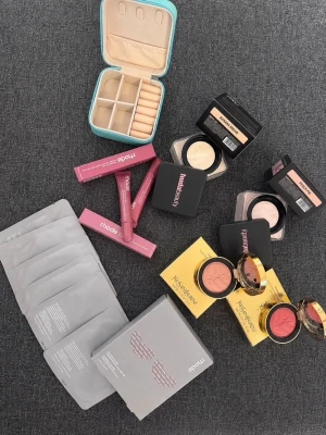 Makeupkit med basprodukter och accessoarer - Ett komplett makeupkit med puder, rouge, läpprodukter i rosa och nude toner, ansiktsmasker och en smidig smyckesask. Innehåller produkter från bland annat YSL och Rhodé. Perfekt för dig som vill ha allt för en fräsch bas och glow.