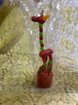 Vintage Färgglad träfigur giraff Leksak  - En liten vitage träfigur föreställande en giraff i rött, grönt och orange. Figuren har en rund bas och är sammansatt av kulor och stavar, vilket ger ett lekfullt uttryck. Perfekt som prydnad eller leksak. Levereras inslagen i plast. 49kr/st , helt ny , finns olika färger kvar 