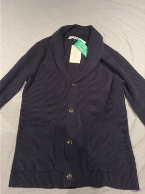 Mörkblå cardigan från Pier One - Säljer mörkblå cardigan från Pier One. Passar inte bra på mig. Riktigt skönt material. Har dock tagit av lapparna nu men aldrig använd bara testad
