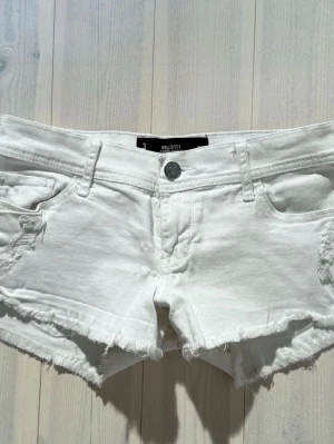 Vita jeansshorts från Hollister - Säljer ett par vita jeansshorts från Hollister med fransiga kanter och slitna detaljer. Tyvärr kommer de ej till användning längre och är i väldigt bra skick.