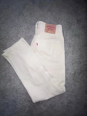 Levi's 501 jeans - off white/beige - Säljer ett par äkta Levi’s 501 i en snygg off white/beige färg. Klassisk 501-modell med rak passform och knappgylf. Perfekta till både vardag och en mer stilren outfit. Storlek: W31 L32  Byxorna är i bra begagnat skick utan några större anmärkningar. Red Tab och läderpatch finns kvar. Det finns dock en liten vit fläck på ena bakfickan. Har inte provat att ta bort den. Skickar snabbt. Pris är inte hugget i sten. 