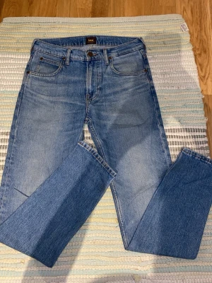 Lee jeans straight - Säljer ett par klassiska blå jeans från Lee i modellen Rider. Jeansen har rak passform, fem fickor och är gjorda i 100% bomull. Perfekta till en avslappnad stil och passar till det mesta. Snygg tvättad look och tidlös design.
