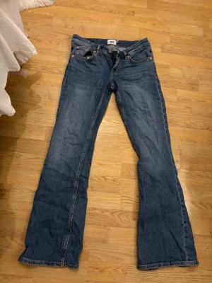 Blå bootcut jeans från 157 - Säljer ett par klassiska blå bootcut jeans från 157. Låg midja och dragkedja med knapp. Materialet är denim i bomull med snygga kontrastsömmar. 