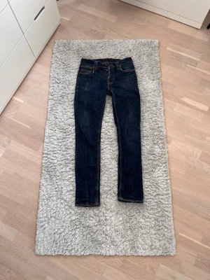 Mörkblå Nudie Jeans - Säljer ett par riktigt feta nudie jeans i modellen Grim Tim och storlek W32 L34. De har riktigt snygga fades och tvätt. Tveka inte att skriva vid intresse eller funderingar, pris går att förhandlas så det är bara att skicka!