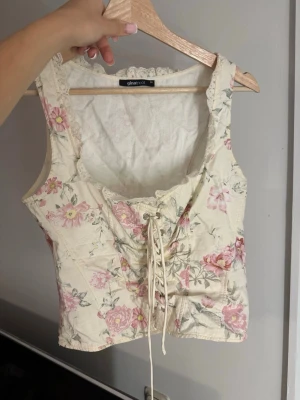 Blommig korsett gina tricot  - Säljer denna populära toppen från gina som inte går att få tag på längre! Använd 2gånger🩷Inga defekter passar som s/m