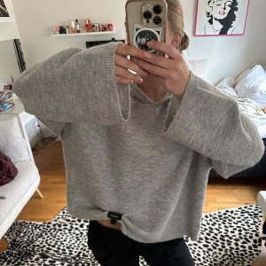 Grå stickad tröja/hoodie - En grå stickad tröja med luva från Gina i nyskick, aldrig använd endast testad, i 7% alpacka.  Sitter oversized så passar L.