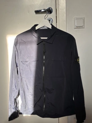 Stone island overshirt -  As snygg mörkblå stone island overshirt i storlek M, använd fåtal gånger men inga defekter på den! Perfekt nu under sommaren och till hösten. Pris kan diskuteras!🙌🤙