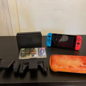 Nintendo Switch – Komplett paket med Minecraft och Tomtoc-fodral - Säljer min Nintendo Switch då den inte används längre. Konsolen fungerar felfritt och allt fungerar som det ska. Den är välanvänd och gummit på vänstra joysticken saknas, men det påverkar inte funktionen.  Ingår:  * Nintendo Switch * Dockningsstation * 2 Joy-Cons * Joy-Con Grip * Joy-Con Comfort Grip * Minecraft (fysiskt spel) * Tomtoc skyddsfodral