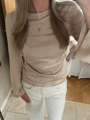 Satinblus - Säljer en beige blus med långa utsvängda ärmar. Använd 1 gång💞