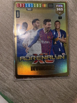 Adrenalyn XL Invincible FIFA 365 kort - Säljer ett glittrigt samlarkort från Adrenalyn XL FIFA 365-serien med motiv av flera kända fotbollsspelare. Kortet har holografisk yta och texten 'Invincible' på framsidan. Perfekt för dig som samlar på fotbollskort eller gillar FIFA 365.