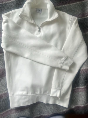 Vit halfzip sweatshirt med krage - Snygg vit sweatshirt med halv dragkedja och hög krage. Tröjan har långa ärmar, ribbade muddar och en clean look utan tryck eller mönster. Slim fit | strl S | ca 170