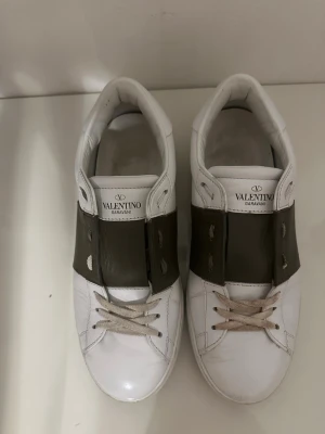 Valentino open skor - Valentino Garavani open sneakers storlek 39 passar 40 skick 9/10 otroligt fint skick färg vit/khaki nypris 7200kr mitt pris 2399kr. Hör av er vid frågor/bilder eller funderingar👌👌